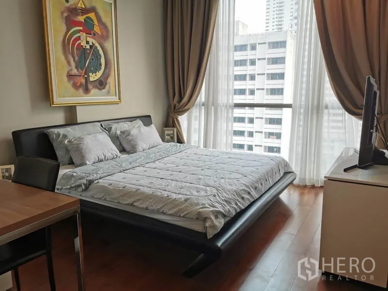 公寓 出租在Watthana, Bangkok - 主卧落地窗享城市景观，现代床架与充足采光。