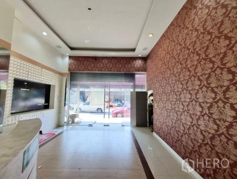 店屋 出租在Watthana, Bangkok - 从大堂望向街景的玻璃门店与卷闸门。