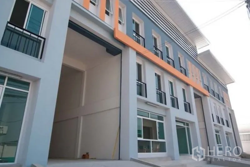 Factory for rent in Bang Sao Thong, Samut Prakan - Facade detail with extra-high roller-door and street-facing windows.
