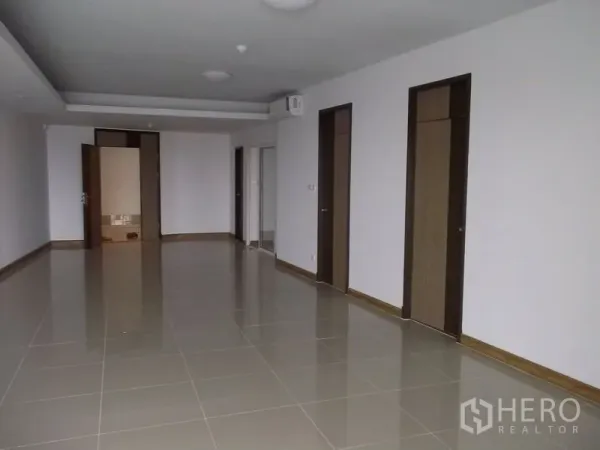 คอนโด ให้เช่าในBangkok - พื้นที่รับแขกและรับประทานอาหารปูกระเบื้องกว้าง มีประตูไม้หลายบานและไฟฝังฝ้า