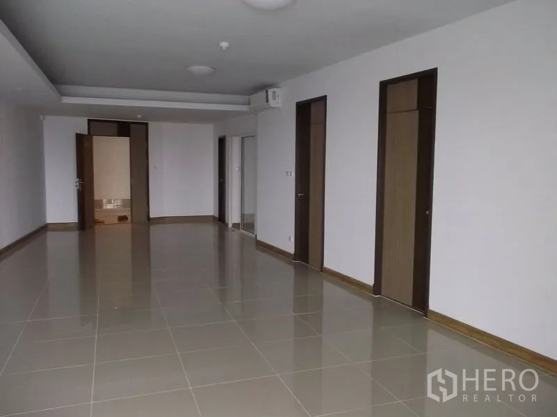 คอนโด ให้เช่าในBangkok - พื้นที่รับแขกและรับประทานอาหารปูกระเบื้องกว้าง มีประตูไม้หลายบานและไฟฝังฝ้า