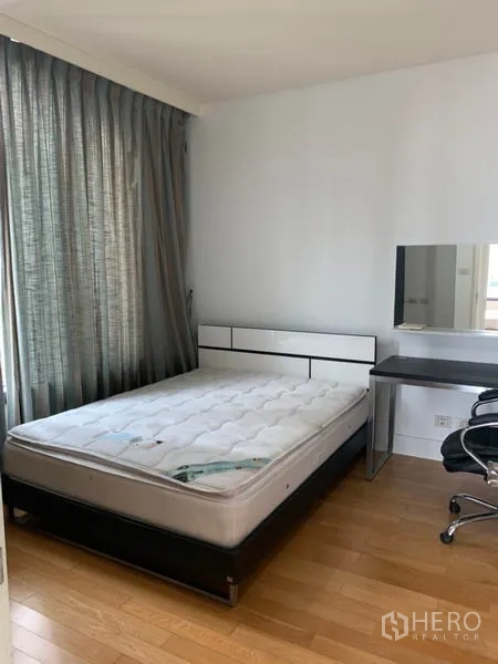 คอนโด ให้เช่าในKhlong Toei, Bangkok - ห้องนอนพื้นไม้ โต๊ะทำงาน และหน้าต่างบานใหญ่พร้อมผ้าม่านกันแสง