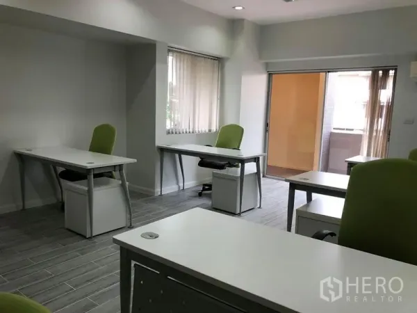 Office Space for rent in Khlong Toei, Bangkok - Corner view of modern office showing windows, sliding door to a small balcony and desks with lockable pedestals.