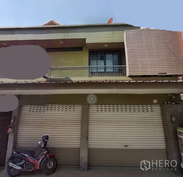 零售空间 出租在Watthana, Bangkok - 两层店屋式门面，双金属卷闸门、阳台与雨棚，位于曼谷瓦他那，靠近BTS On Nut。