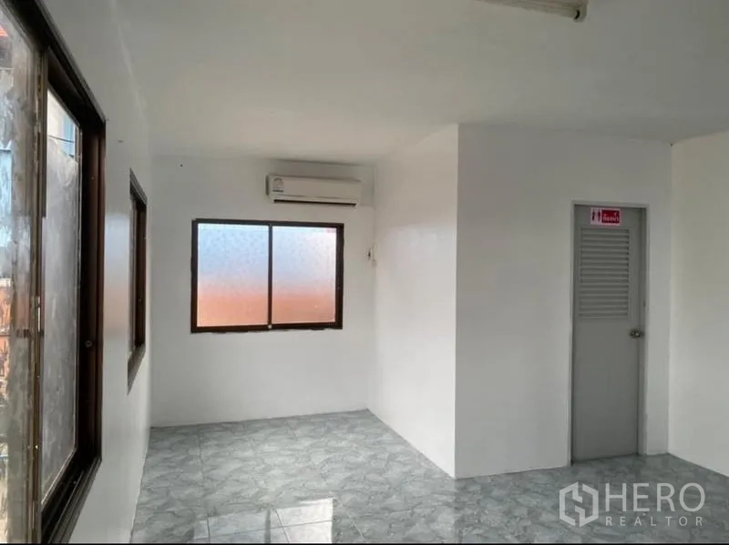 Warehouse for rent in Mueang Rayong, Rayong - Air-conditioned office room with tiled floor, windows, and an entrance to the restroom.