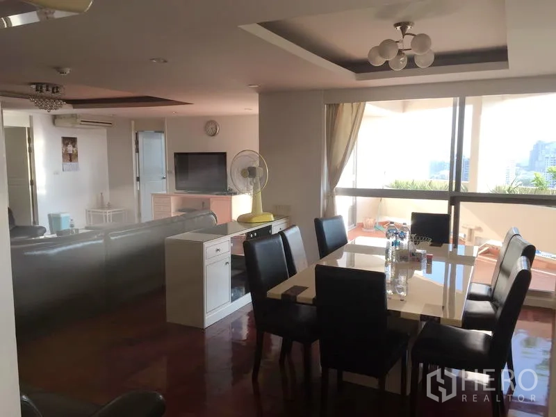 Condominium for rent in Watthana, Bangkok - Dining area with six-seat table opening to a large balcony with city views.