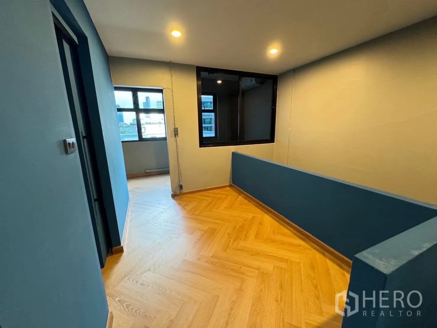 家庭办公室 for rent in Watthana, Bangkok - 楼上走廊，鱼骨纹木地板与室内窗隔断。