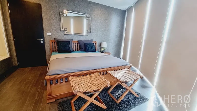 公寓 出售在Watthana, Bangkok - 卧室配木质床架、床尾长凳与高遮光百叶帘。