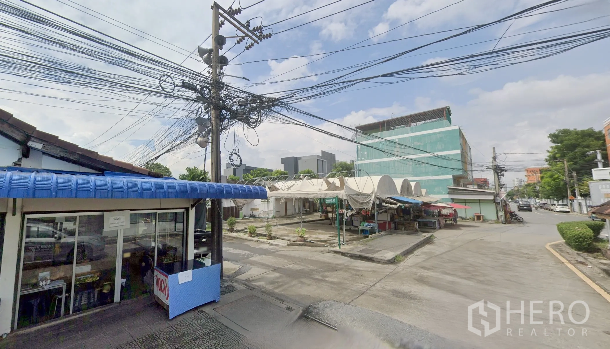 Land for sale in Bang Kapi, Bangkok - Street view showing small shops, overhead utility lines, and low-rise buildings near the land plot.