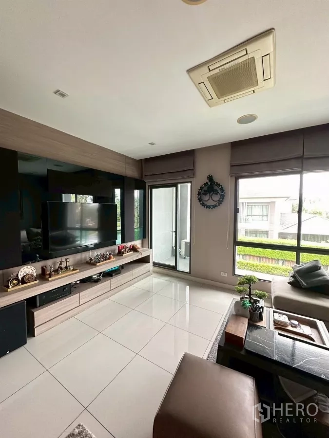 Detached House for sale in Bang Lamung, Chon Buri - Upstairs family room with TV cabinet, balcony access and glossy floor tiles.