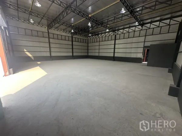 คลังสินค้า ให้เช่าในPrawet, Bangkok - มุมโกดังแสดงหลังคาฉนวนกันความร้อน ขอบสีดำ และพื้นคอนกรีตเรียบ.