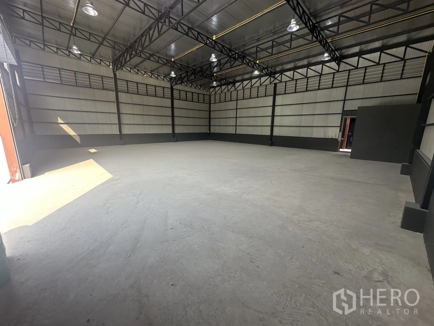 คลังสินค้า ให้เช่าในPrawet, Bangkok - มุมโกดังแสดงหลังคาฉนวนกันความร้อน ขอบสีดำ และพื้นคอนกรีตเรียบ.