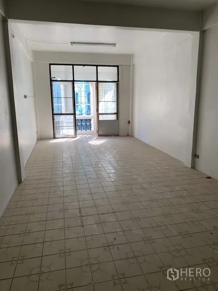 店屋 出租在Pathum Wan, Bangkok - 楼上长形房间，瓷砖地面，玻璃门通往小阳台。