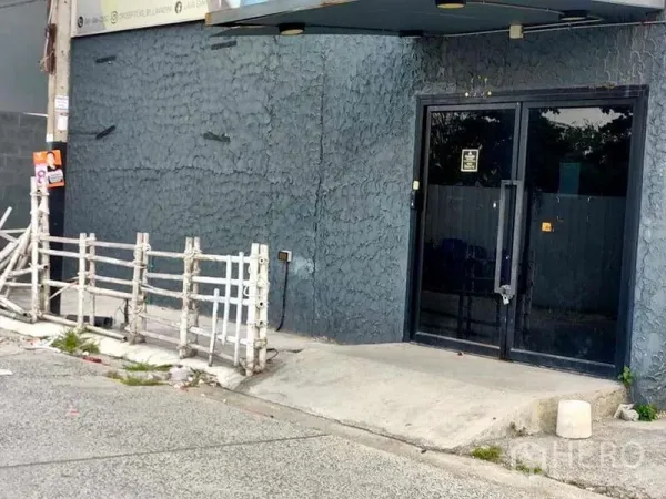 Warehouse for rent in Suan Luang, Bangkok - Main entrance with glass double doors and textured exterior wall beside a small ramp.