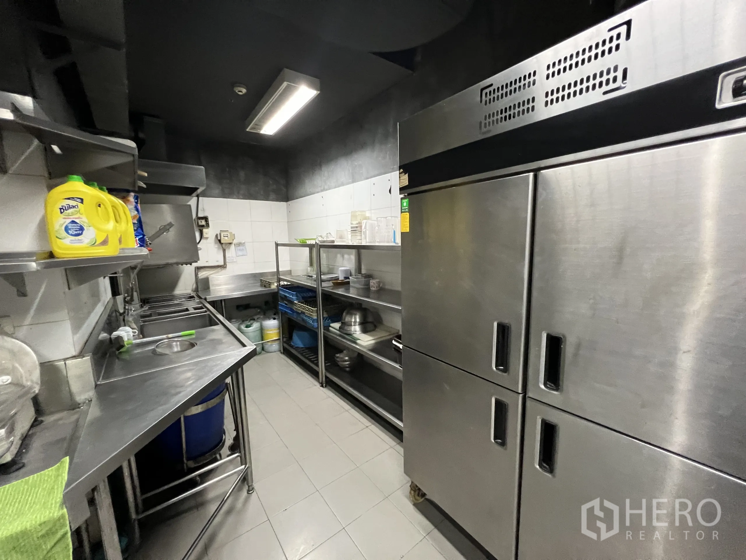 พื้นที่ขายปลีก ให้เช่าในWatthana, Bangkok - มุมล้างจานและแพนทรี มีอ่างสแตนเลส ชั้นวาง และตู้เย็นสองประตู