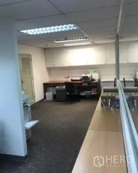 办公空间 出租在Khlong Toei, Bangkok - 打印与茶水区，内置白色柜体、办公桌与地毯地面，旁为玻璃隔断。