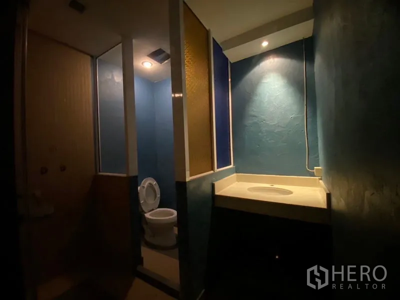 พื้นที่ขายปลีก ให้เช่าในWatthana, Bangkok - ห้องน้ำโทนสีน้ำเงิน มีห้องส้วมและเคาน์เตอร์อ่างล้างหน้า