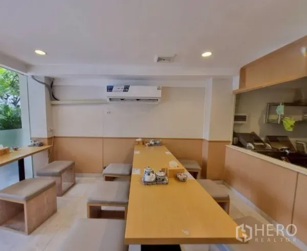 店屋 出租或出售在Watthana, Bangkok - 一层用餐区，长木桌与空调。