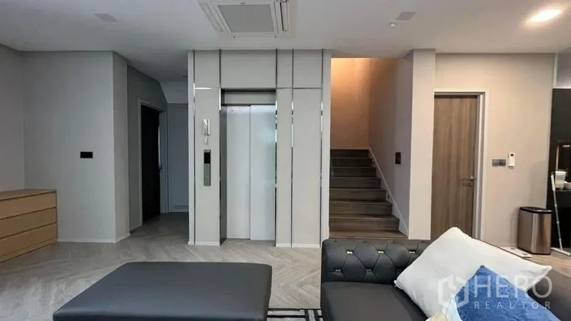 Detached House for sale in Saphan Sung, Bangkok - Private home elevator and staircase off the living room in a modern interior.