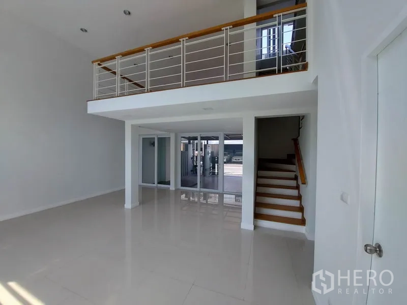 ทาวน์เฮาส์ ขายในWang Thonglang, Bangkok - โถงนั่งเล่นแบบโอเพ่นแพลน มีชั้นลอย พื้นเงางาม บันได และประตูกระจกบานใหญ่