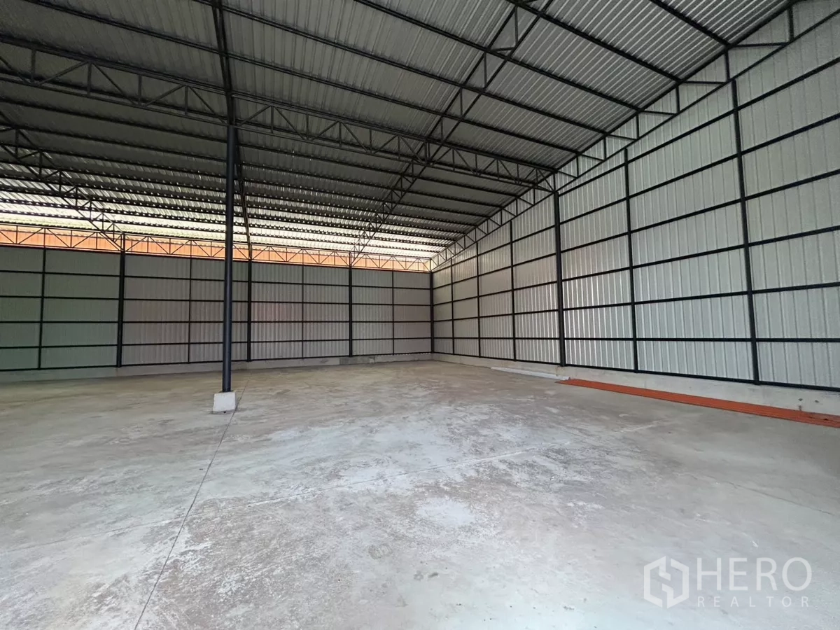Warehouse for rent in Khlong Toei, Bangkok - Corner view of warehouse with metal sheet walls, high ceiling and clean loading surface.