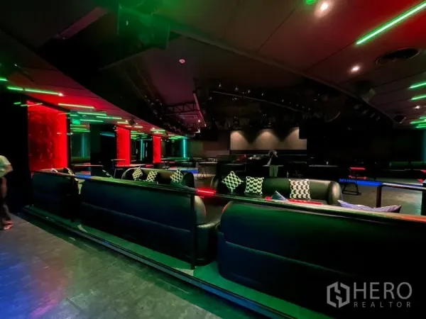 零售空间 出租在Ratchathewi, Bangkok - 宽敞休息区，黑色沙发、舞台灯架与多彩灯效。