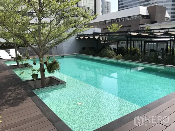 Condominium for rent or sale in Bang Rak, Bangkok - Rooftop swimming pool with trees, sun deck, and city views at a Bang Rak condominium.