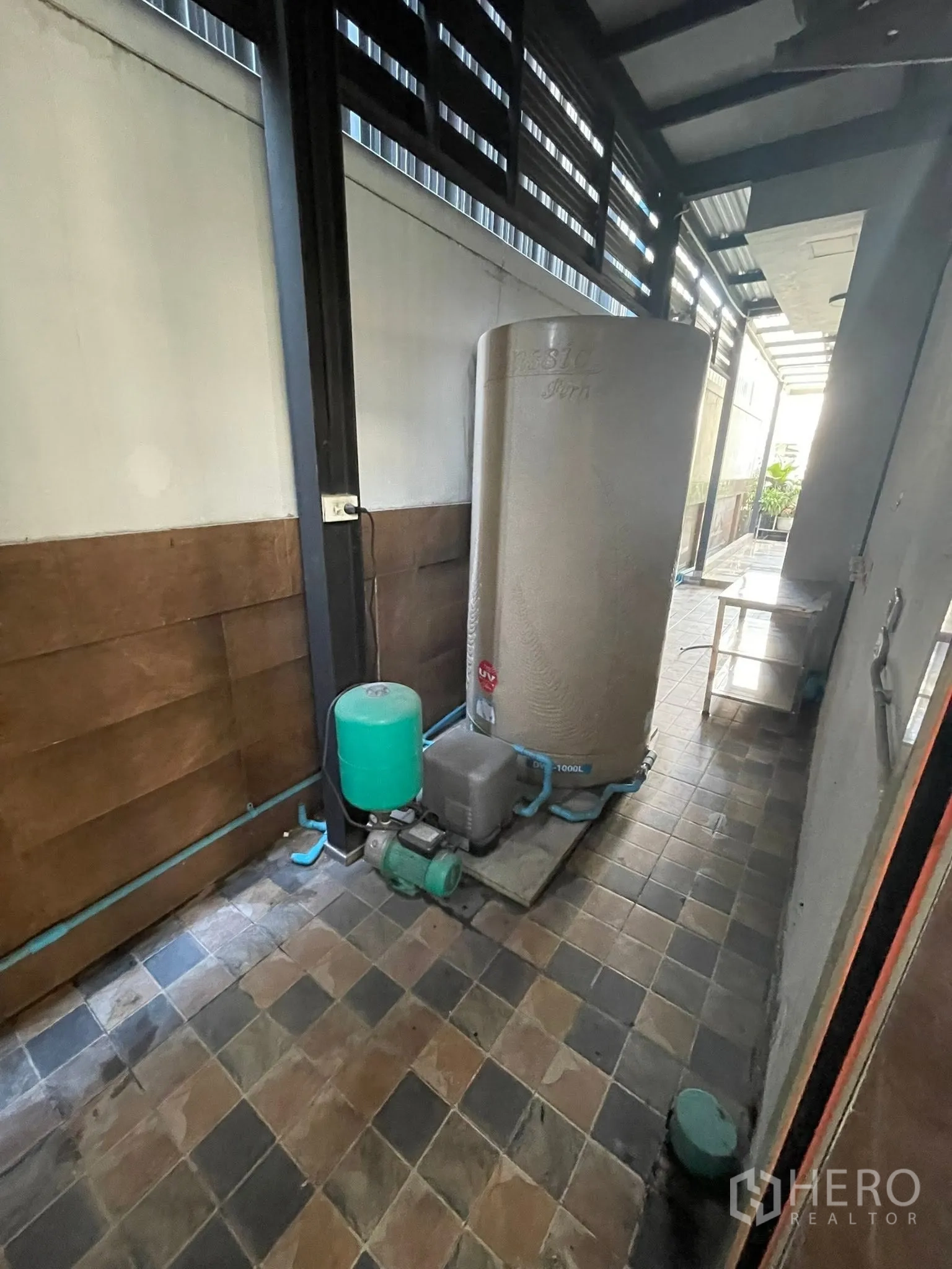 Detached House for rent or sale in Lam Luk Ka, Pathum Thani - Outdoor service area with large water tank and pump on tiled flooring.