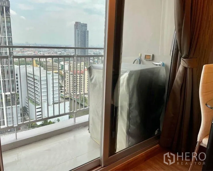 Condominium for rent in Huai Khwang, Bangkok - High-floor balcony with railing, washer hookup and open skyline view.