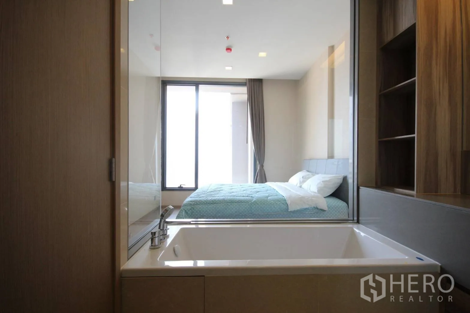 Condominium for rent in Watthana, Bangkok - Bathtub beside a glass partition overlooking the bedroom and city light.