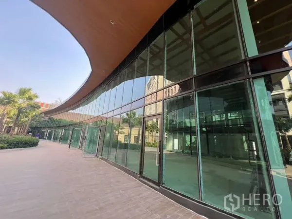 零售空间 出租在Watthana, Bangkok - 弧形玻璃立面的商铺门面，落地窗与入口清晰可见