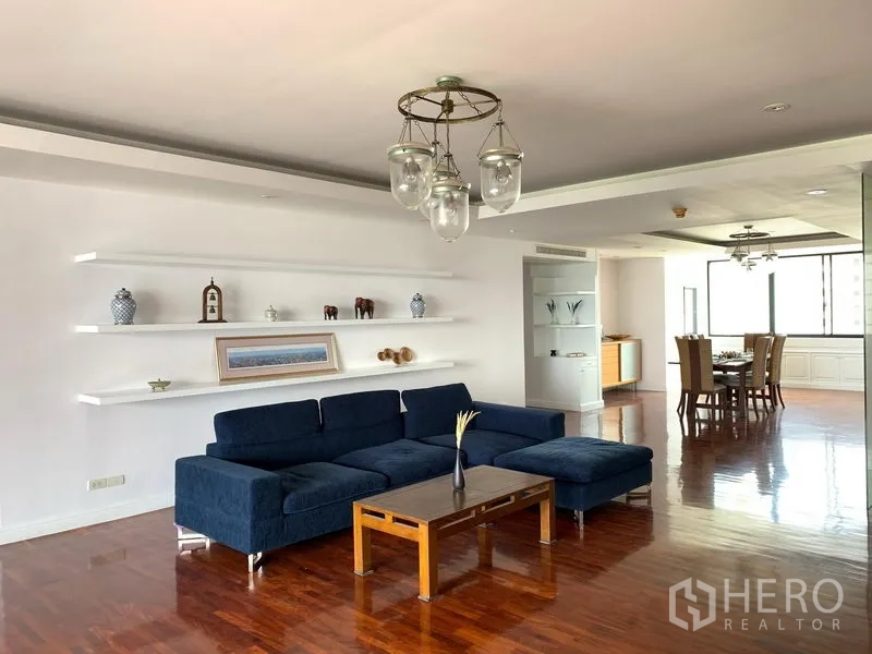 公寓 出售在Khlong Toei, Bangkok - 明亮客厅，海军蓝沙发、悬浮置物架与木地板