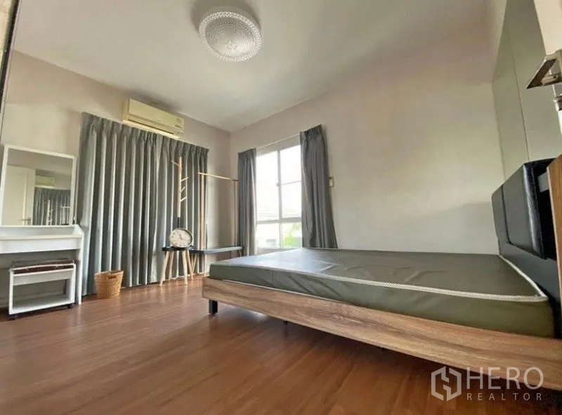 Detached House for rent or sale - Bedroom with wood flooring, bedframe, vanity, large windows, gray curtains and wall‑mounted air conditioner.