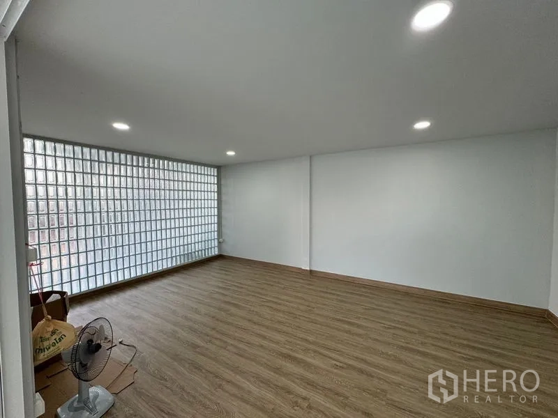 Home Office for rent in Bueng Kum, Bangkok - Spacious room with wood floors and a full glass-block wall for natural light.