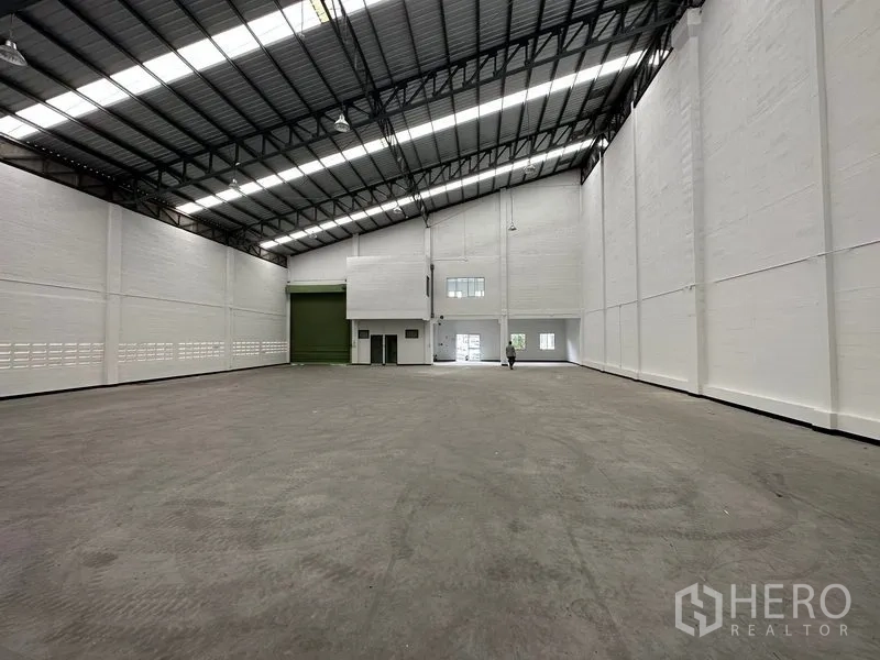 โรงงาน ให้เช่าในKhlong Luang, Pathum Thani - ฮอลล์โรงงานแสดงประตูโหลดสินค้าสีเขียว พื้นคอนกรีต และบล็อกสำนักงานชั้นลอย