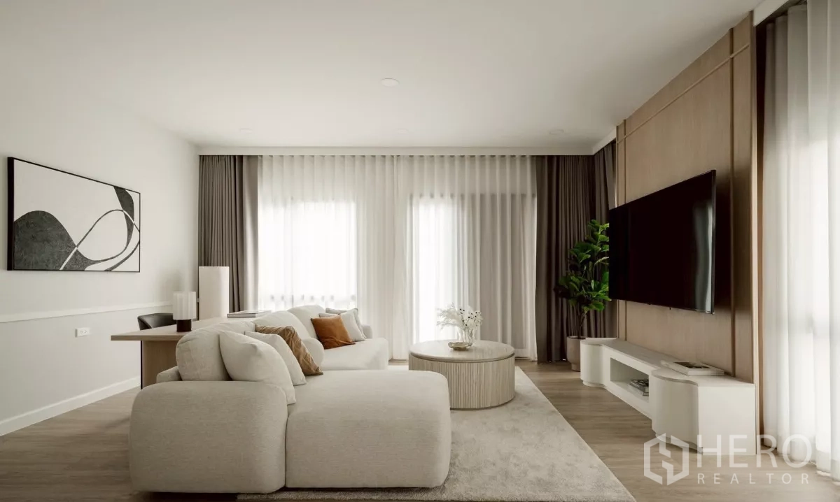 Detached House for rent in Bang Phli, Samut Prakan - Cozy lounge with sectional sofa, wall-mounted TV and large windows