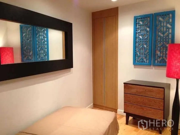 คอนโด ให้เช่าในKhlong Toei, Bangkok - ห้องนอนกะทัดรัด มีกระจกเงาบนผนัง ตู้บิลท์อิน ลิ้นชักไม้ และโคมไฟตั้งพื้นสีแดง