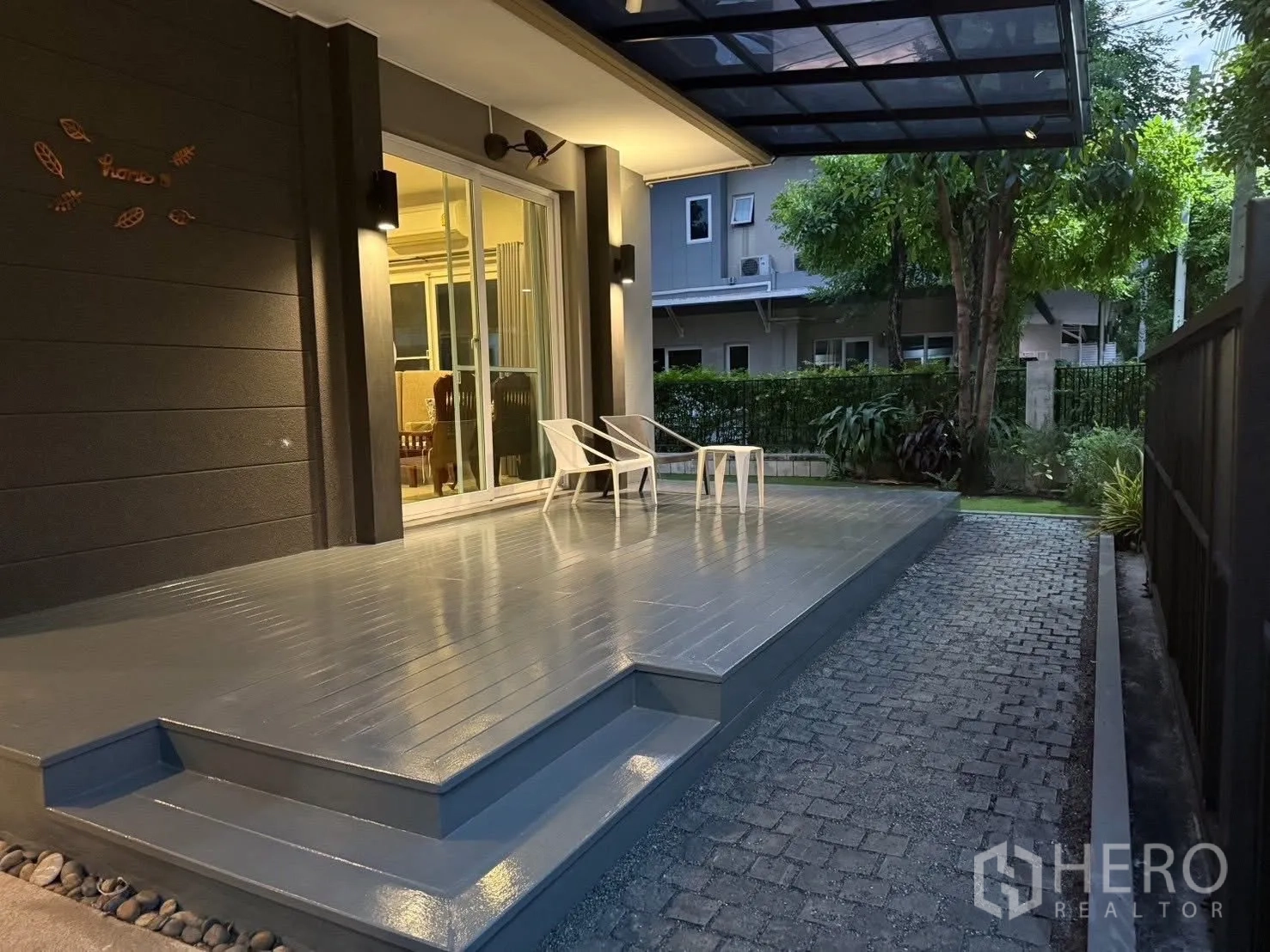 Detached House for rent in Bang Na, Bangkok - Covered front deck with sliding glass doors and two chairs overlooking the garden.