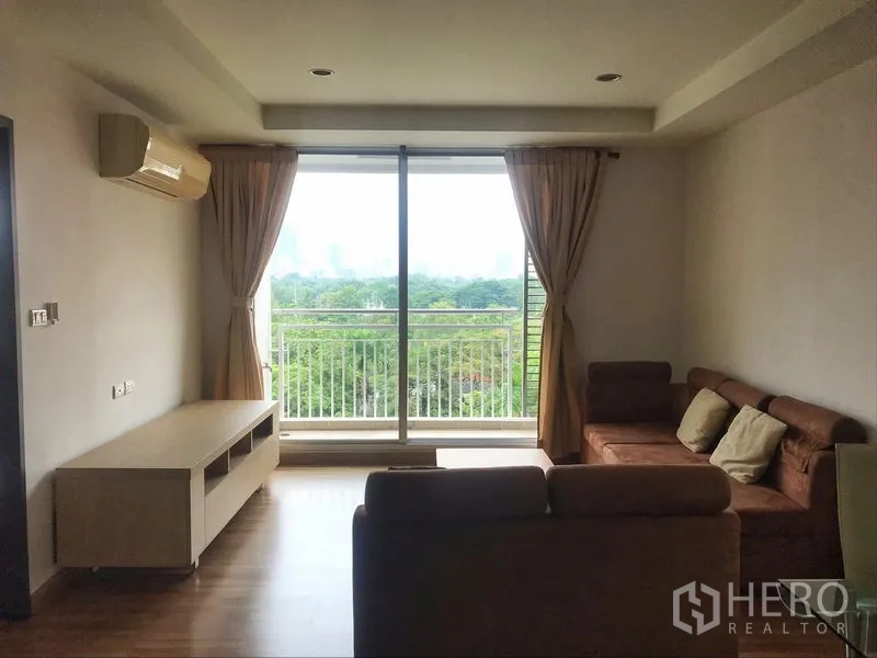 คอนโด ให้เช่าในKhlong Toei, Bangkok - มุมนั่งเล่นมีโซฟาเข้ามุมติดระเบียงรับวิวสวนสีเขียว