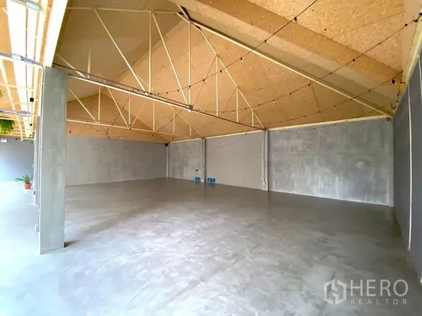 零售空间 出租在Watthana, Bangkok - 开放式店铺，高挑斜屋顶与水泥地面。