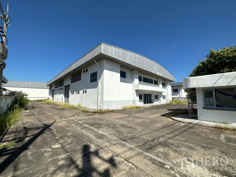 โรงงาน ให้เช่าในChon Buri - มุมมองภายนอกอาคารโรงงานคู่ มีลานโหลด ทางสัญจร และป้อมยาม ภายในรั้วรอบขอบชิด