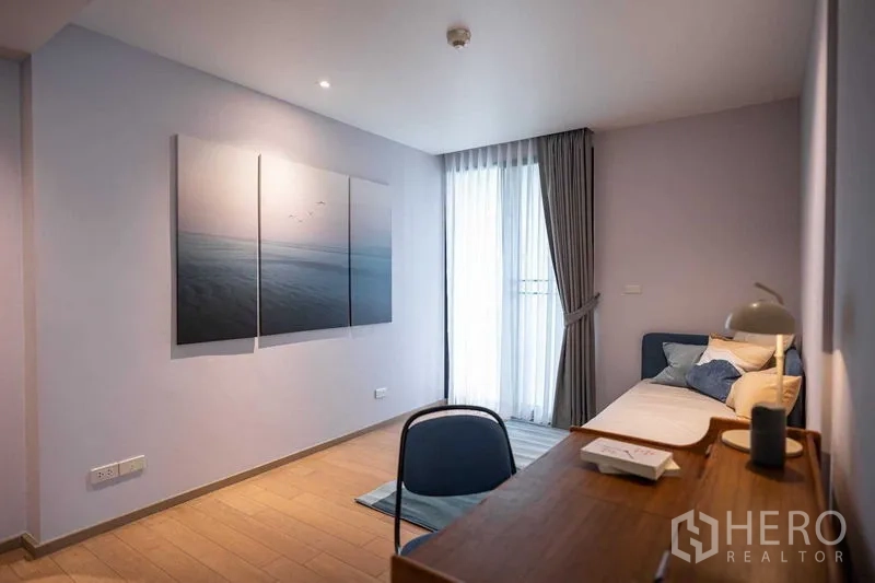 คอนโด ให้เช่าหรือขายในPathum Wan, Bangkok - มุมมองห้องนอนรองพร้อมโต๊ะทำงาน ภาพศิลป์สามชิ้น และแสงธรรมชาติ