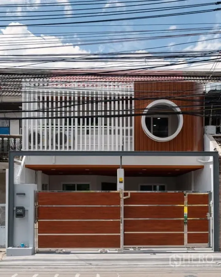 Townhouse for sale in Din Daeng, Bangkok - Contemporary townhouse facade with slatted screens and a circular window near MRT Huai Khwang.