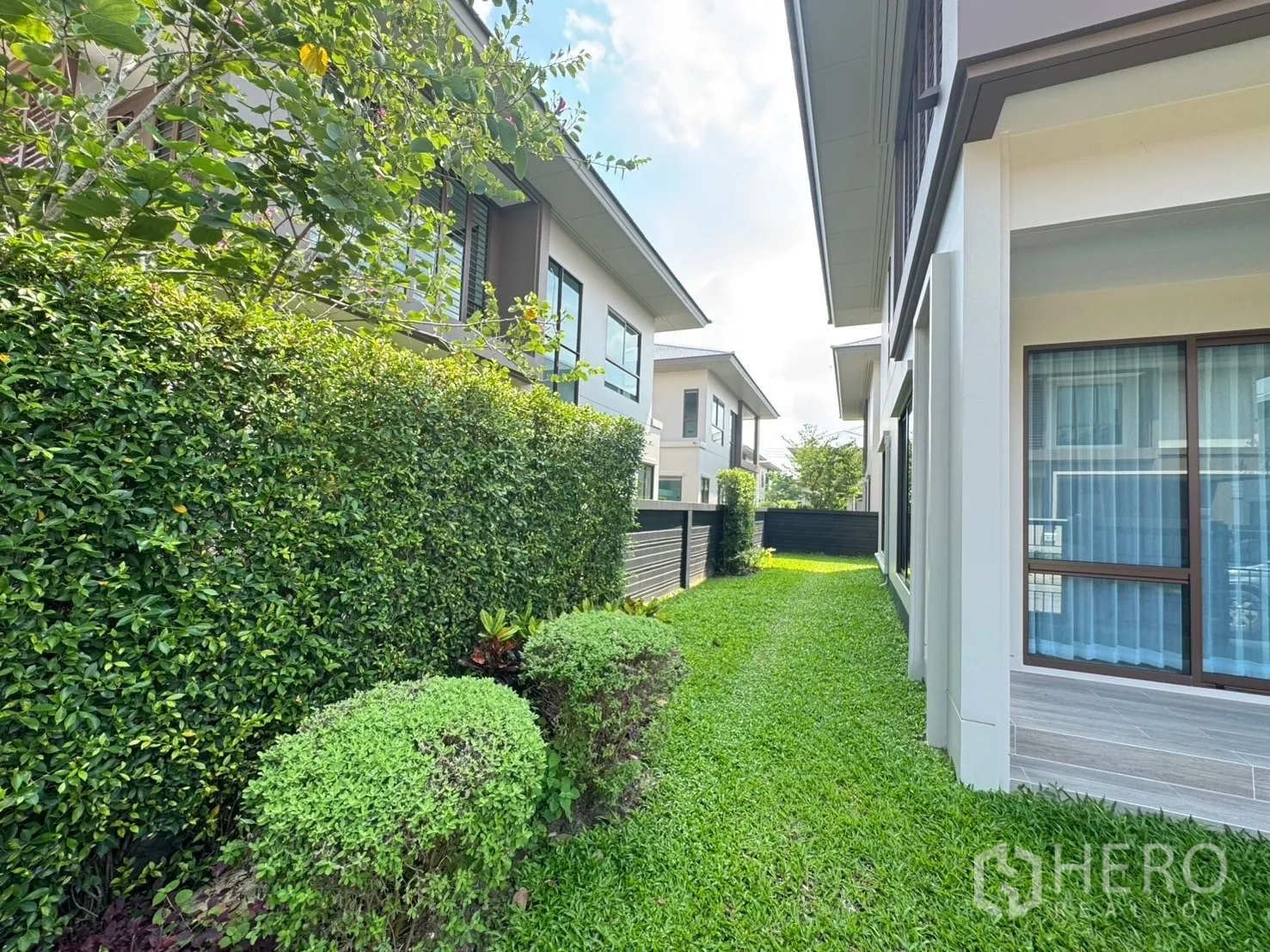 บ้าน ให้เช่าหรือขายในBang Kapi, Bangkok - สวนข้างบ้านกับรั้วพุ่มไม้ตัดแต่งเรียบร้อยและสนามหญ้าสีเขียว