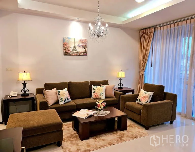 อพาร์ทเมนท์ ให้เช่า - ห้องนั่งเล่นสไตล์อบอุ่น โซฟาสีน้ำตาล เก้าอี้เดี่ยว โคมแชนเดอเลียร์ และหน้าต่างม่านโปร่ง