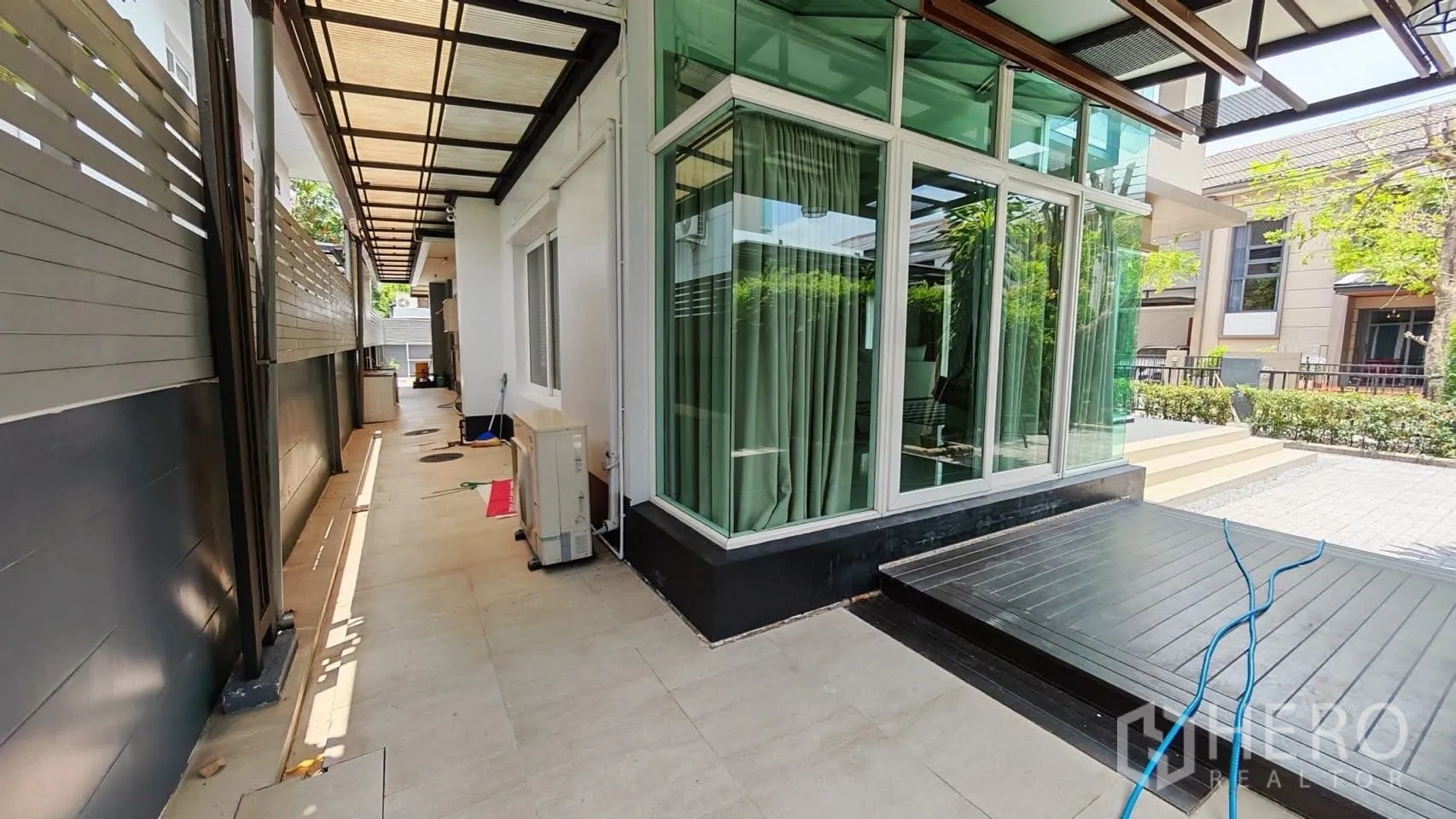 Detached House for rent or sale in Bang Phli, Samut Prakan - Side walkway with canopy roofing and glass corner windows of the house.