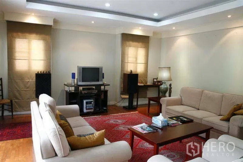 Detached House for rent in Phaya Thai, Bangkok - Bright living room with beige sofas, recessed lighting, wooden flooring and a media console.