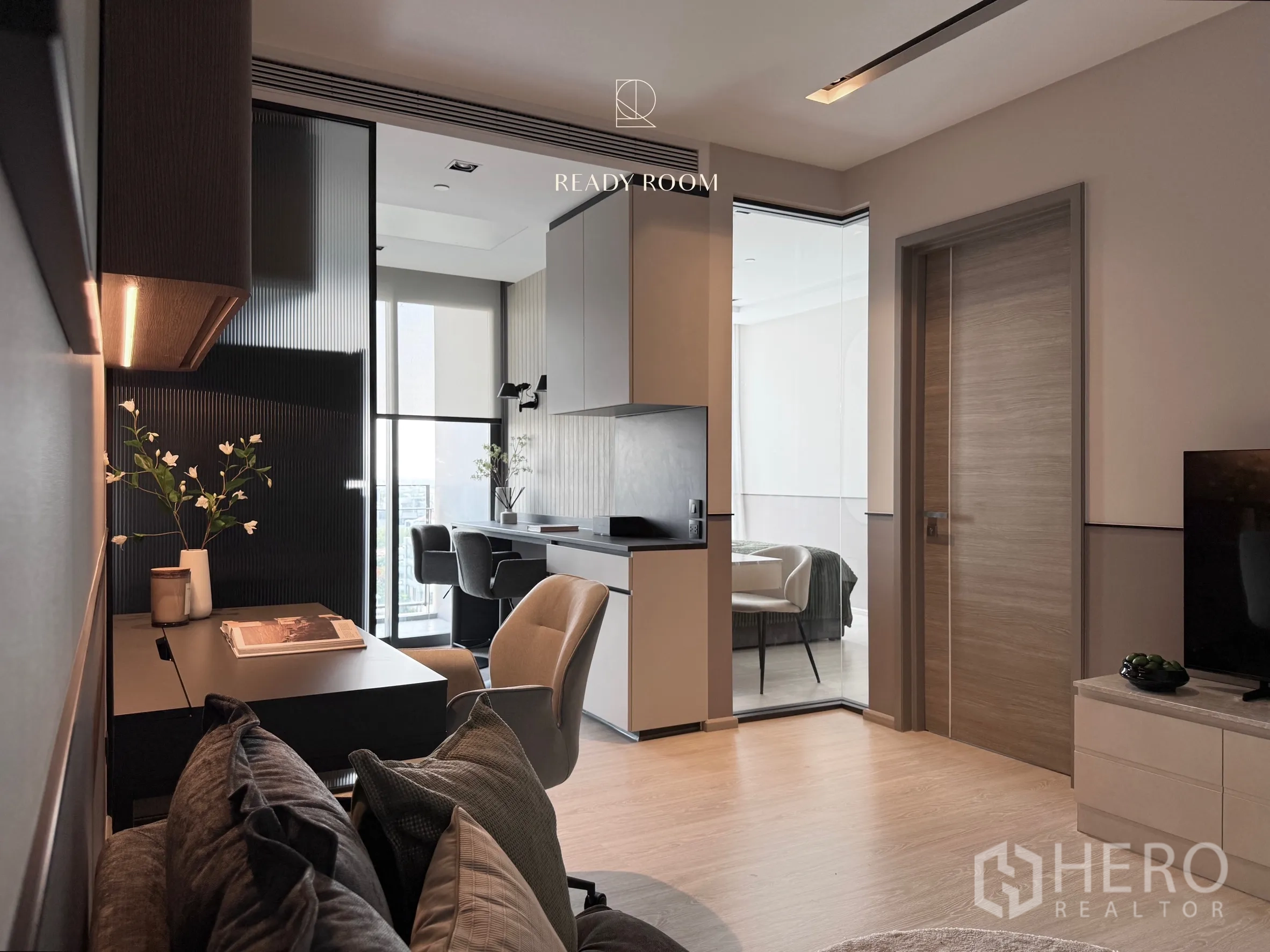 คอนโด for rent in Khlong Toei, Bangkok - มุมโต๊ะทำงานและครัวเชื่อมต่อไปยังห้องนอนสว่างด้วยฉากกั้นกระจก.