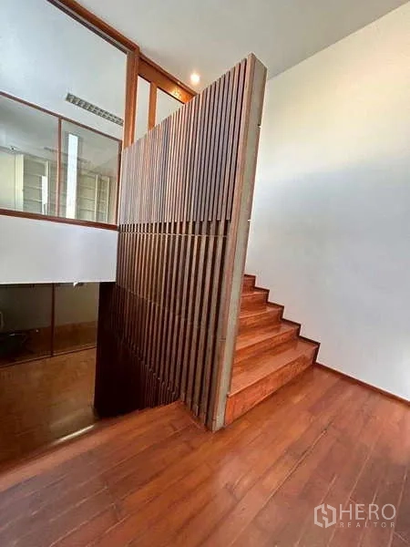 Home Office for rent or sale in Bang Phli, Samut Prakan - Stair landing featuring vertical wooden slat divider and timber steps beside glass walls.