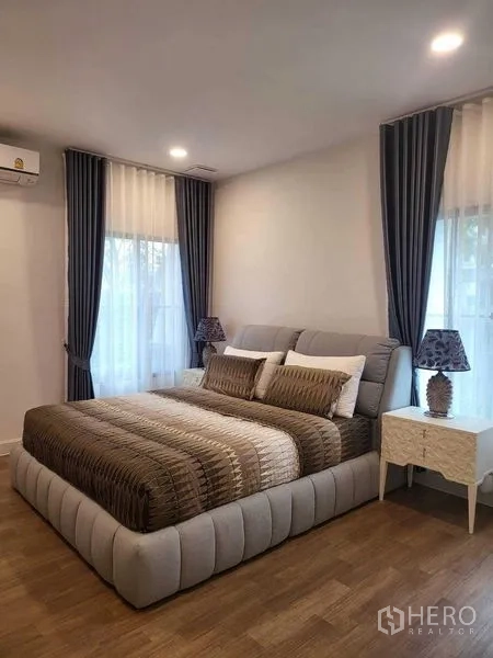 บ้าน ให้เช่าในSaphan Sung, Bangkok - ห้องนอนเตียงใหญ่ พื้นไม้ และหน้าต่างสูงพร้อมผ้าม่าน